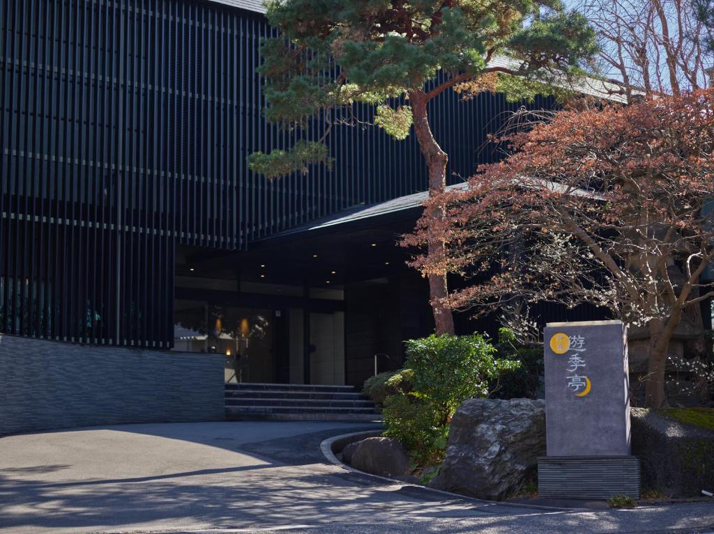 un edificio con una señal delante de él en Ito Yukitei, en Ito