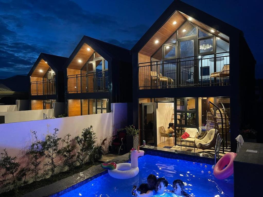 Hidden Haven Subic Villa w/ Infinity Pool في سوبيك: مجموعة أشخاص في مسبح في بيت