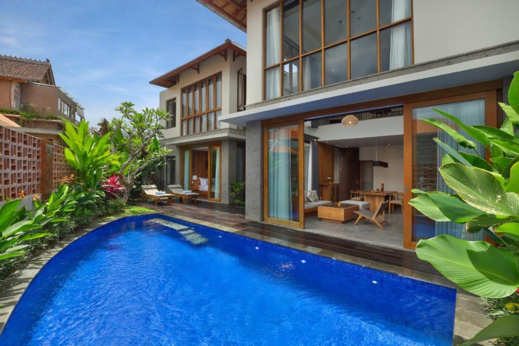 an image of a swimming pool in front of a house at Teratai Villa Canggu by Ini Vie Hospitality in Canggu