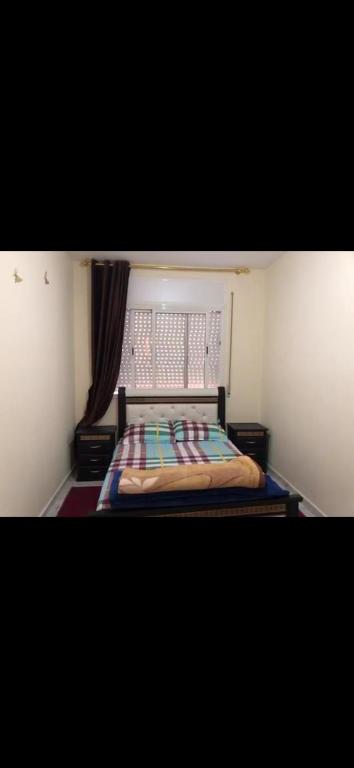 um quarto com uma cama e uma janela em Ait mzal em Khemisset