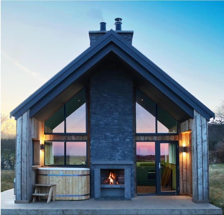 a house with a fireplace in front of it at Coastal Eco-Lodge in Elie