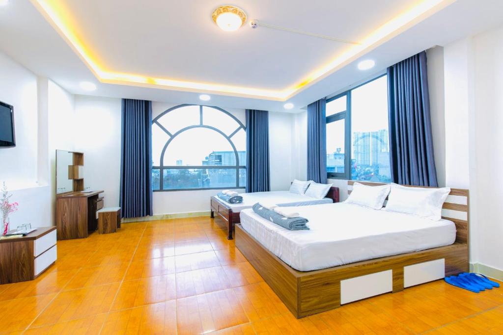 een slaapkamer met 2 bedden en een groot raam bij Hoa Cúc Phương Hotel Dĩ An - Bình Dương in Dĩ An