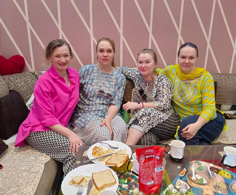 Un groupe de quatre femmes assises sur un canapé dans l'établissement Friends Home Stay - Agra, à Agra