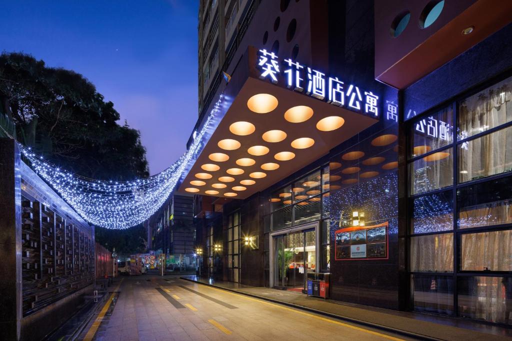 un bâtiment avec des lumières de Noël allumées la nuit dans l'établissement Sunflower Hotel & Residence, Shenzhen, à Shenzhen