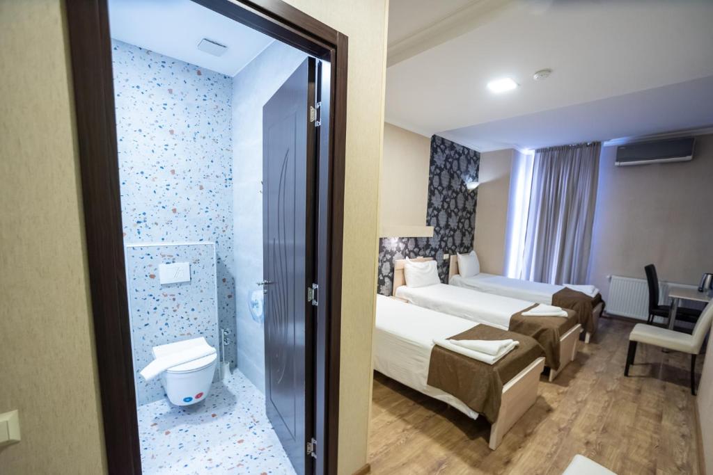 Postel nebo postele na pokoji v ubytování Tiflis Hotel