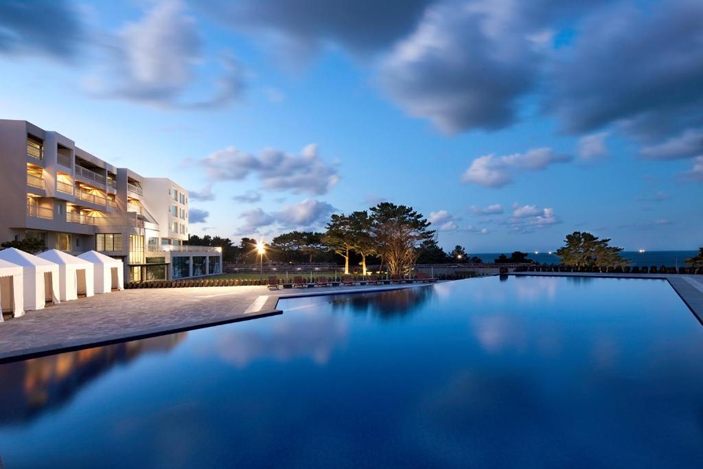 a swimming pool in front of a building at night at Villa de Aewol in Jeju