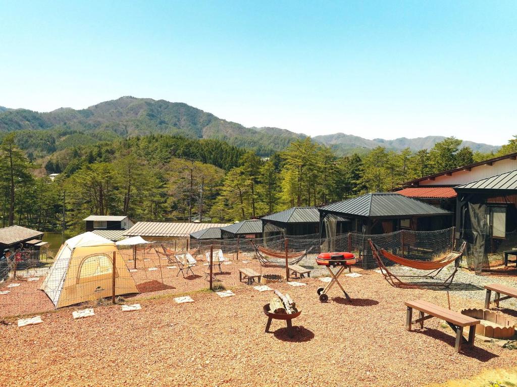 una zona de acampada con tienda, mesas de picnic y bancos en Oogute Kohan Shirasagi So en Shimojo mura