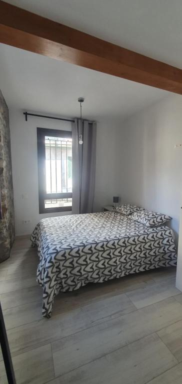 ein Schlafzimmer mit einem Bett in einem Zimmer mit einem Fenster in der Unterkunft APARTAMENTO EN EL CASCO HISTÓRICO DE PLENTZIA II in Plentzia