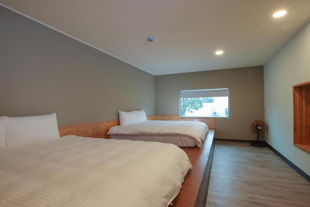 恆春的住宿－峰樹屋，一间卧室设有两张床和窗户。