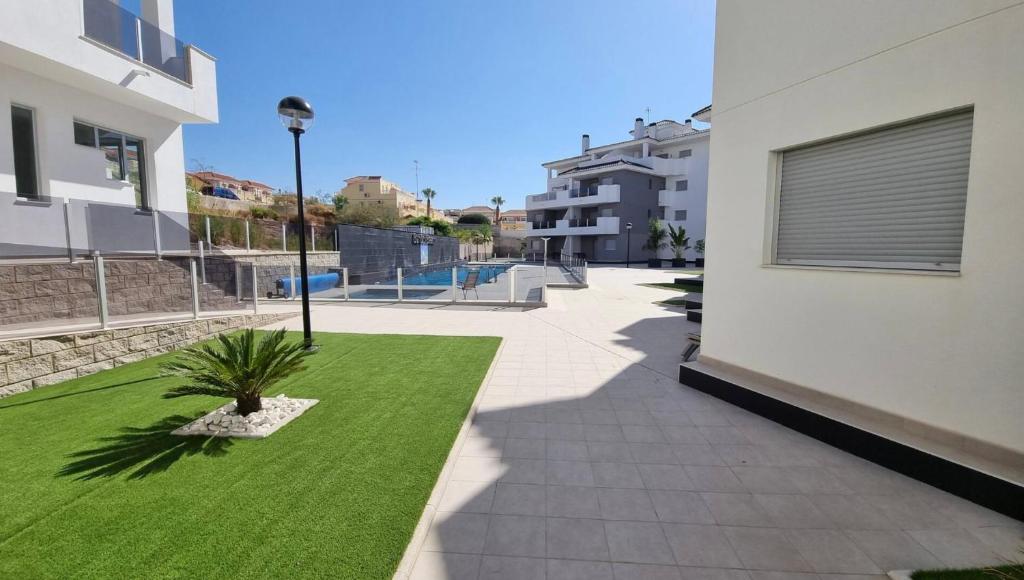 une cour avec de l'herbe verte à côté d'un bâtiment dans l'établissement Modern 3 Bedroom 7 Guests Sun Golf Beach Apartments, à Villacosta