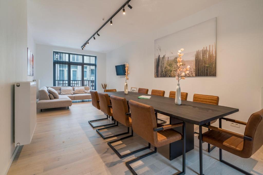 una sala da pranzo con un lungo tavolo e sedie di Maison les Bruyères 1 - Luxueus wonen Blankenberge a Blankenberge