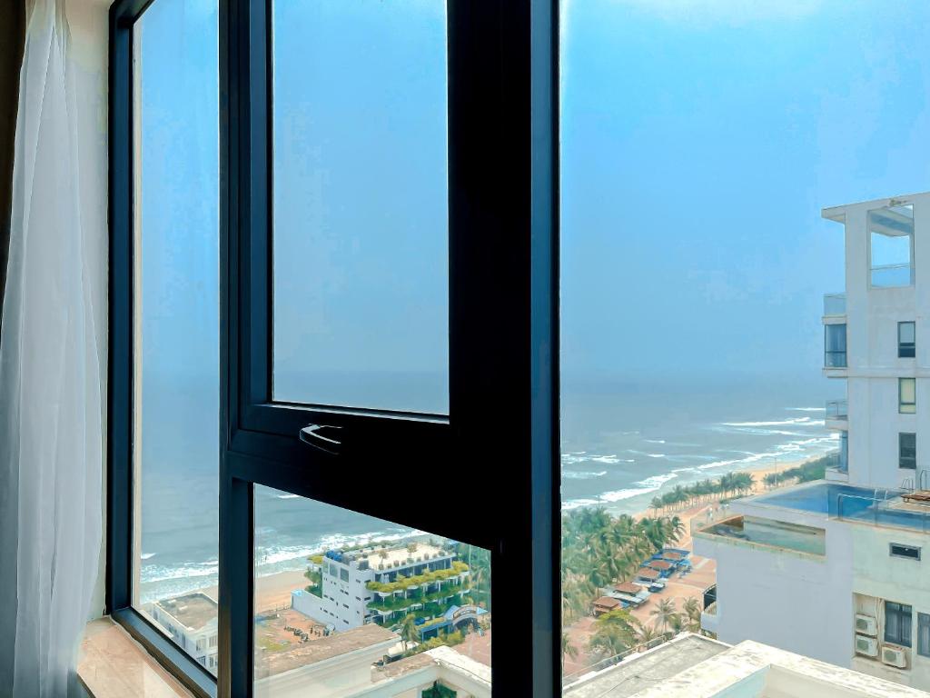 a view of the beach from a window in a building at Paris Deli Danang Beach Hotel in Danang