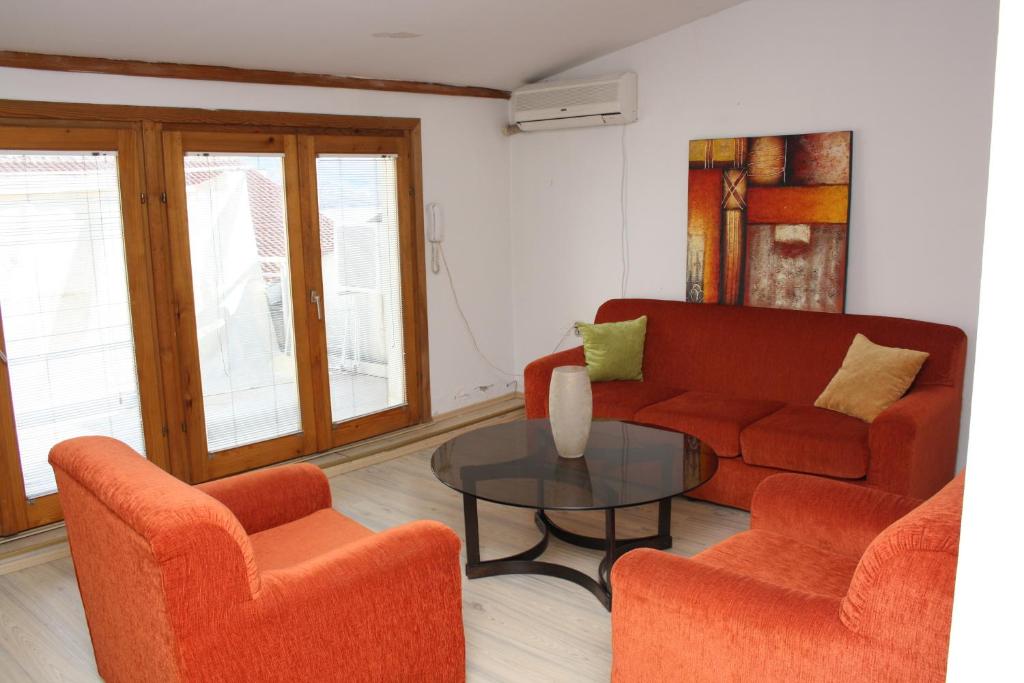 een woonkamer met een bank, 2 stoelen en een tafel bij Villa Greta Pipile in Ohrid