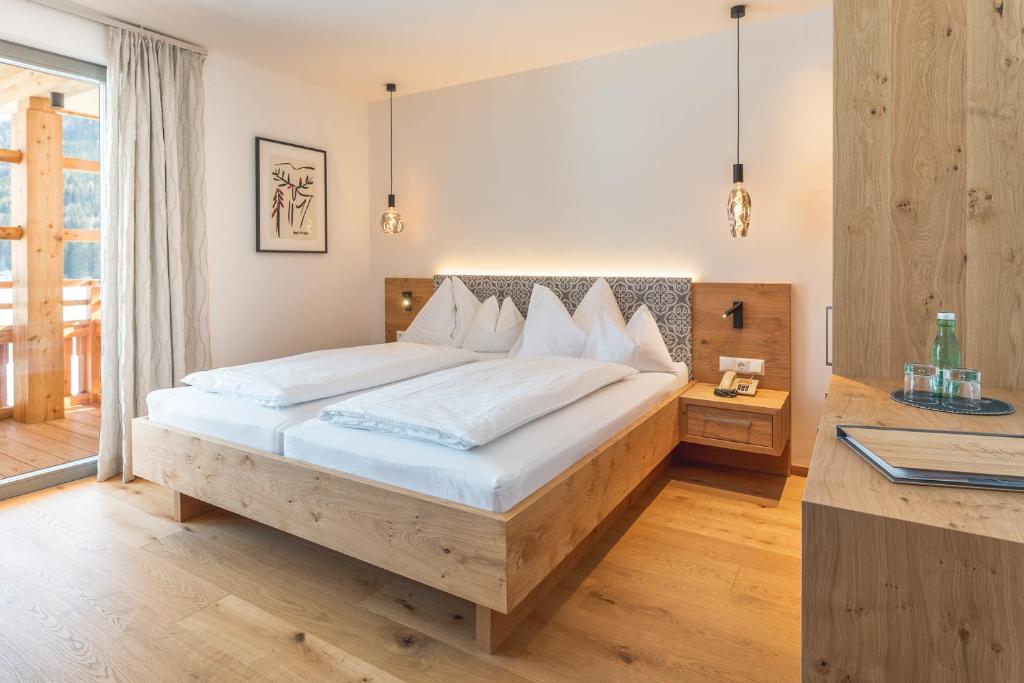 Postel nebo postele na pokoji v ubytování Das Leonhard - Naturparkhotel am Weissensee