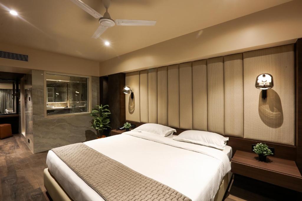 a bedroom with a large bed and a shower at Hotel Corporate in Navi Mumbai