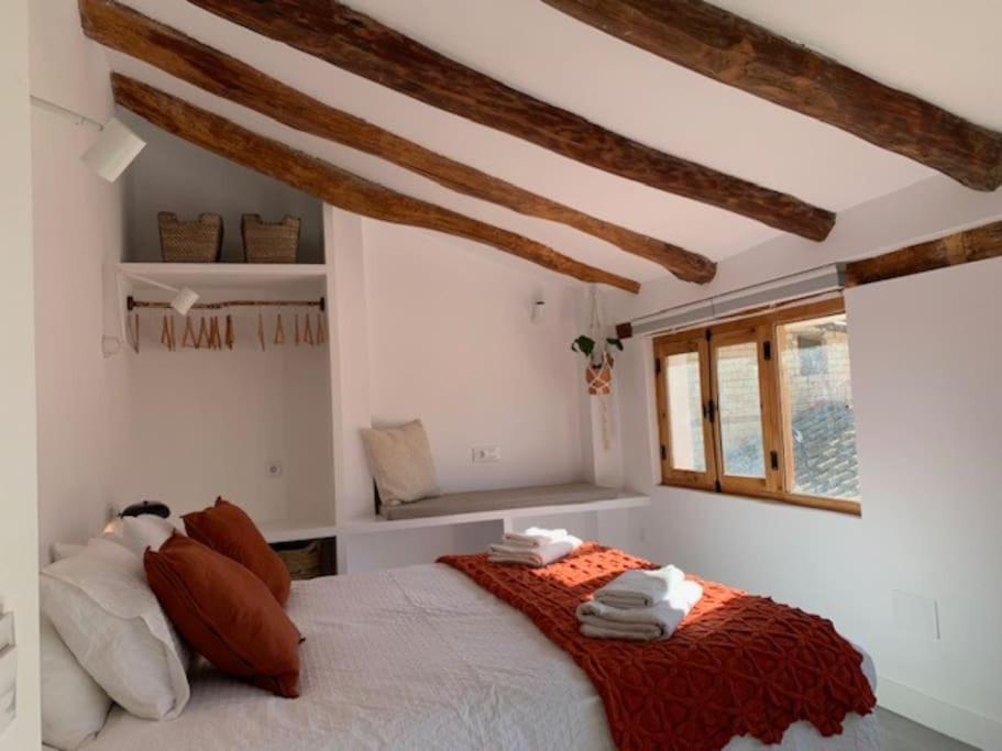 a bedroom with a bed with pillows and a window at Casa Valleta in Tivenys