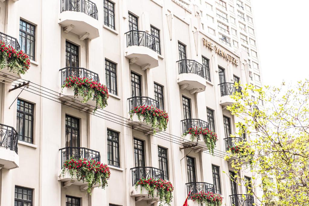 a white building with flowerpots on the windows at The Yangtze Boutique Shanghai in Shanghai