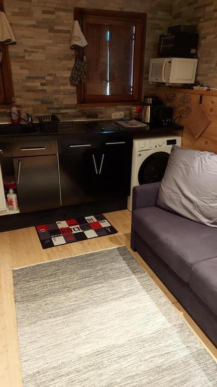 a living room with a couch and a kitchen at SebRem in Megève