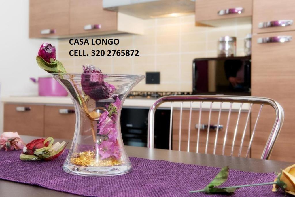 a vase with flowers in it on a table at Casa Longo in Castellammare del Golfo