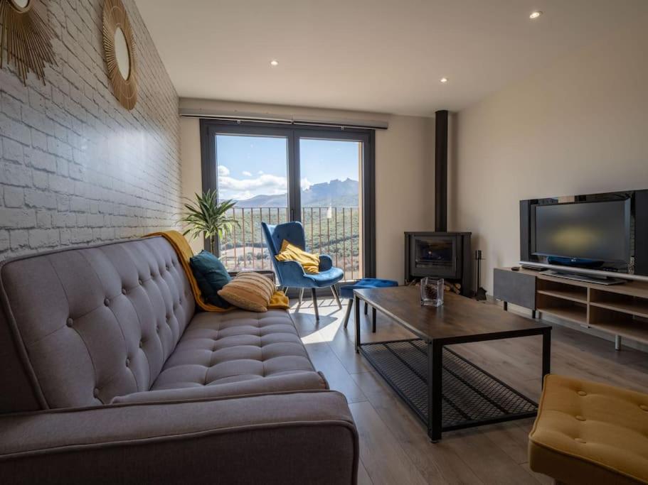 a living room with a couch and a tv at Casa Rural El Moradel Añon in Añón