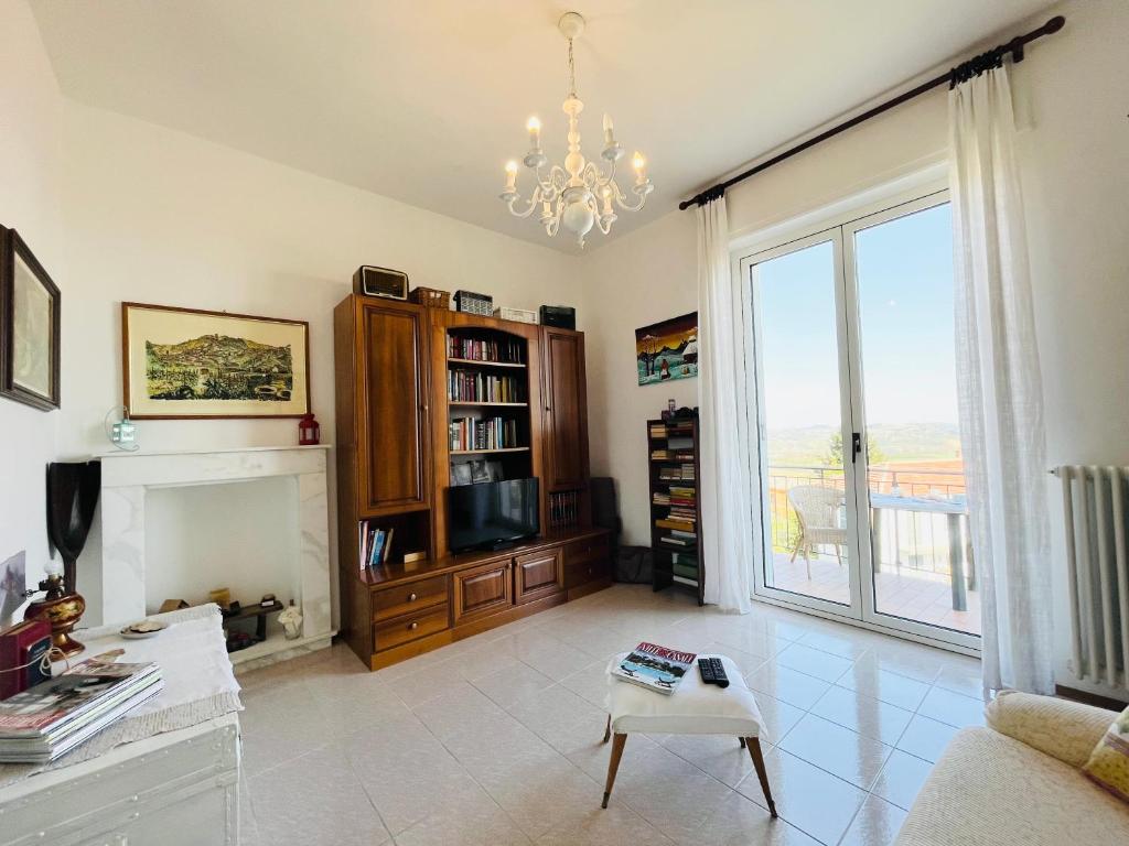sala de estar con chimenea y lámpara de araña en Casa vacanze con vista panoramica, en Frassinello Olivola