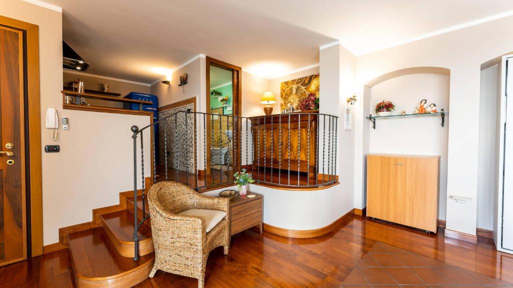 ein Wohnzimmer mit einem Stuhl und einer Treppe in der Unterkunft Attico tra i due Mari in Novoli