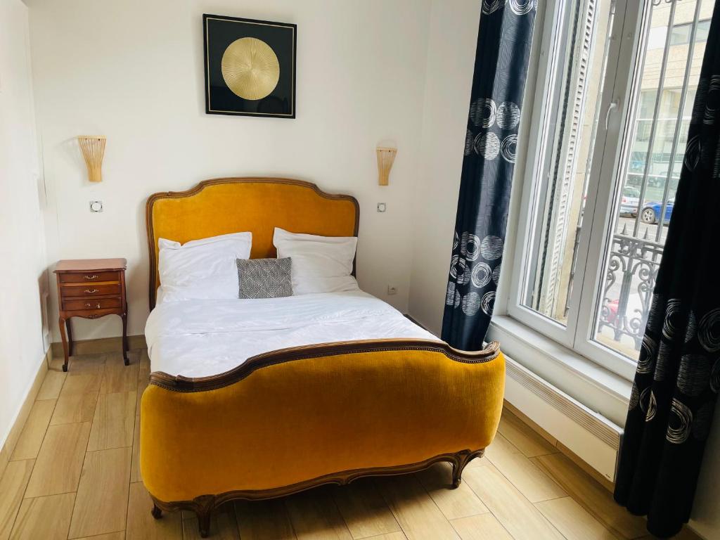 a bed in a room with a large window at L’appart’ du village in Nancy