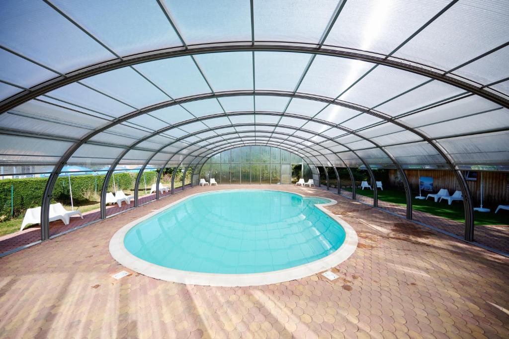 an indoor swimming pool with a retractable roof at Glamping the Vosges in Corcieux