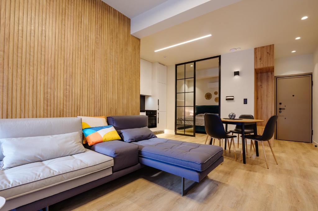ein Wohnzimmer mit einem Sofa und einem Tisch in der Unterkunft Goudi 4th Floor Greece Apartments in Athen