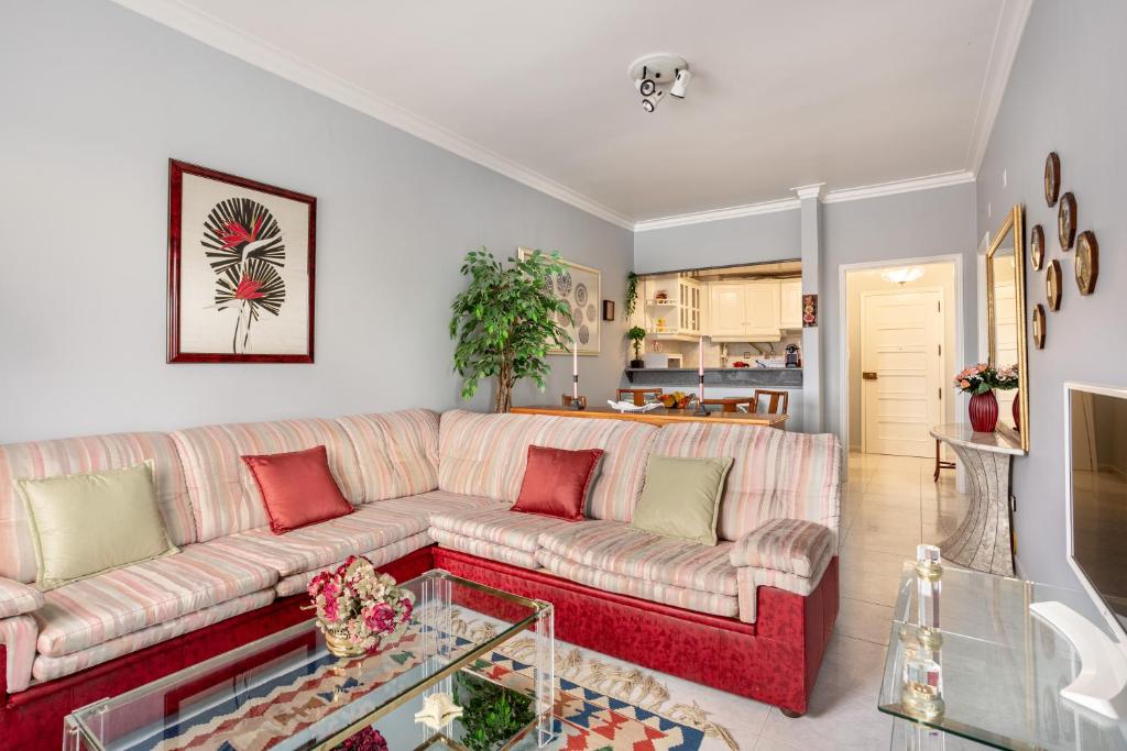 a living room with a couch and a table at JOIVY Vibrant flat with balcony in Costa da Caparica