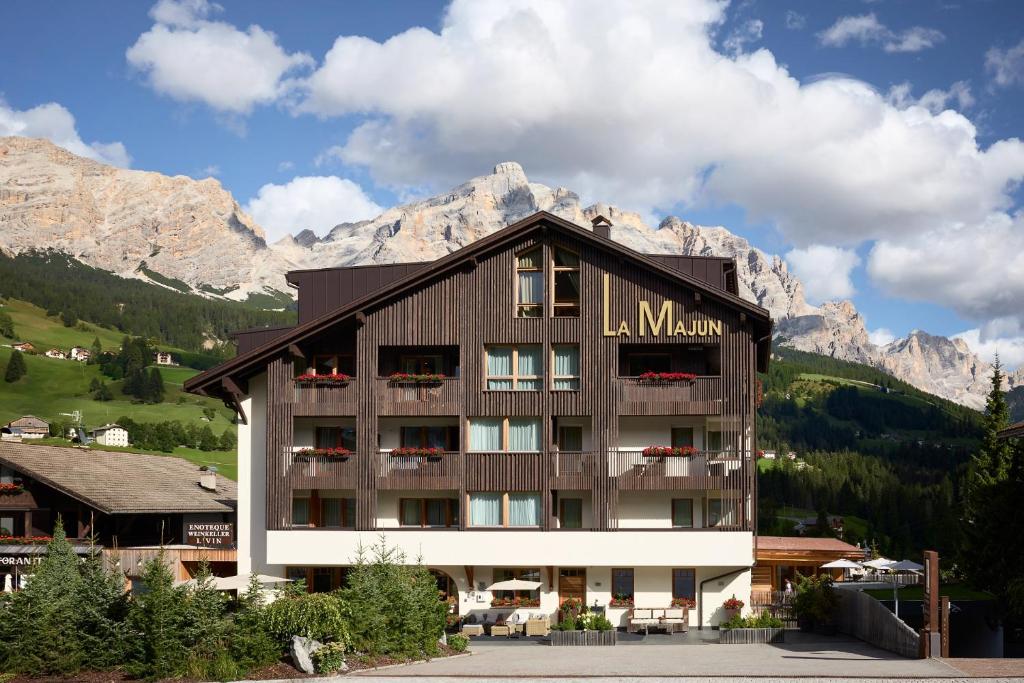 a large building with mountains in the background at Hotel La Majun in La Villa