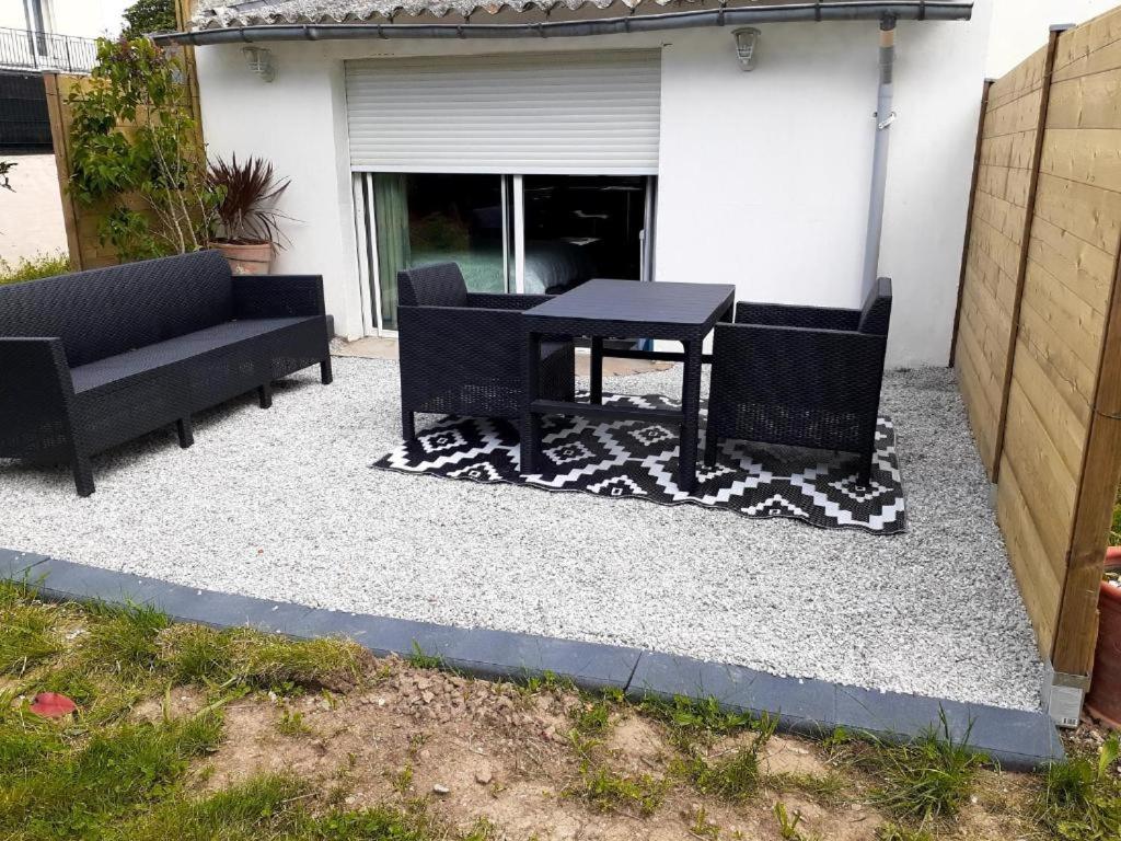 a patio with two couches and a table on a rug at Concarneau studio avec terrasse in Concarneau
