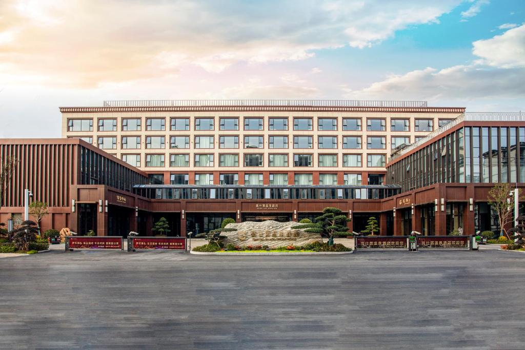a large building with a fountain in front of it at Gao Shi Di Hot Spring Hotel Yangzhou in Yangzhou