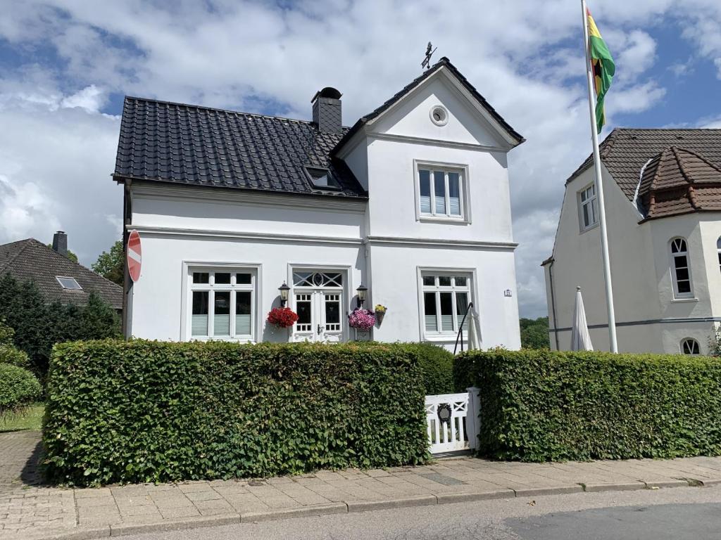 a white house with a flag in front of it at fewo1846 - Pauline - zauberhafte Wohnung für 2 Personen mit Terrasse und Garten in Glücksburg