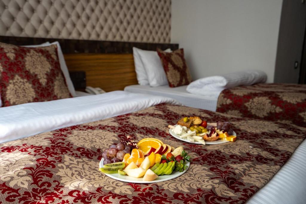 a hotel room with two beds with plates of fruit on the bed at Mevre Hotel in Antalya