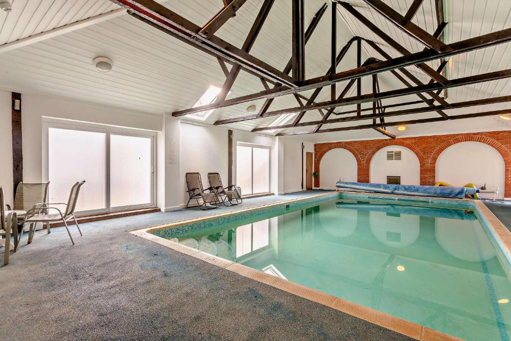 a large indoor swimming pool in a building with at The Retreat in Tibenham