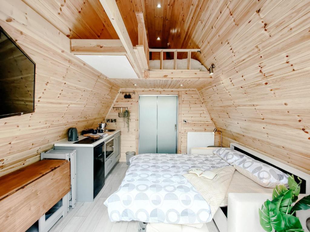 een slaapkamer in een blokhut met een bed bij Bective Mill Glamping & Camping 