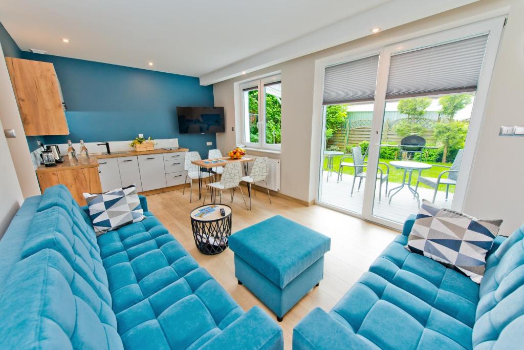 uma sala de estar com um sofá azul e uma mesa em Domek przy promenadzie em Colberga