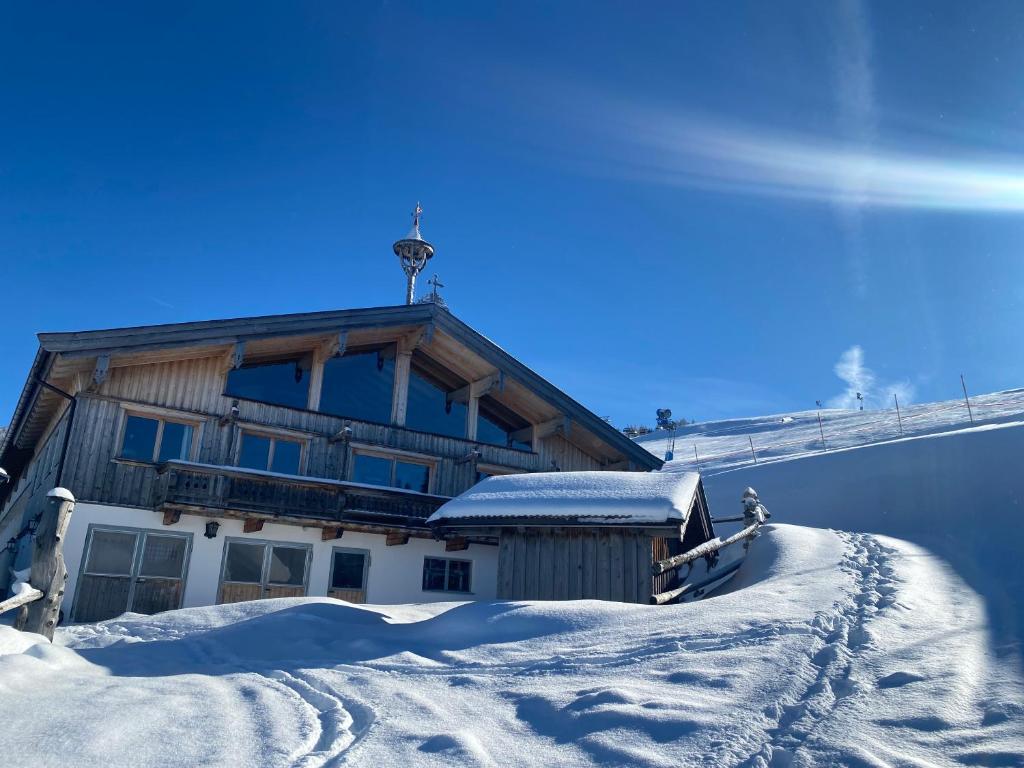 um edifício no topo de uma montanha coberta de neve em Au Hochalm Chalet em Söll