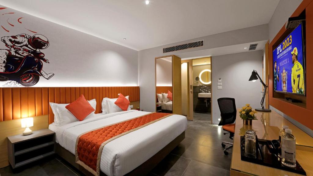 a hotel room with a large bed and a television at Hotel City Keys By Rivido, Electronic City in Bangalore