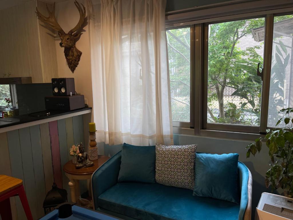 a living room with a blue couch and a window at Star Wish B&amp;B in Dongshan