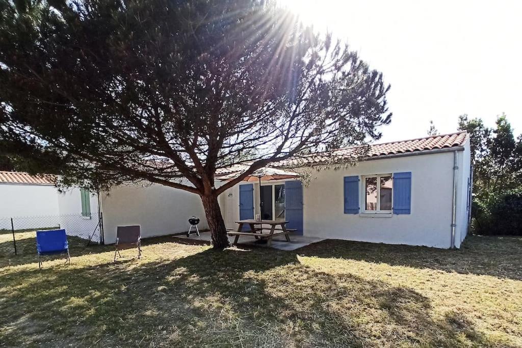 a small white house with a tree in the yard at Maison Rose-Trémière avec jardin clos - Plage à 500m in Chaucre