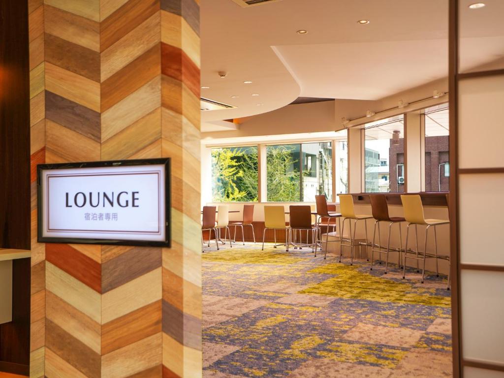 een lobby met een wachtkamer met een loungetafel bij Hotel New Gaea Domemae in Fukuoka