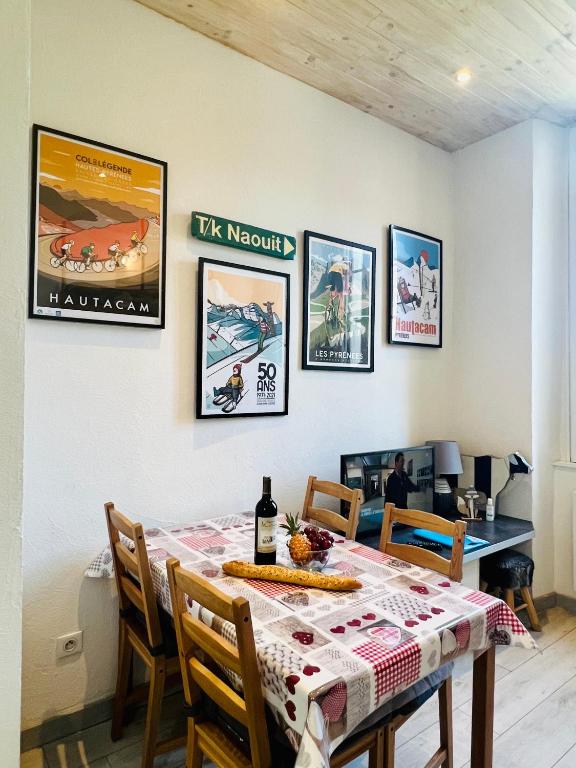 une salle à manger avec une table et quelques tableaux au mur dans l'établissement Studio Endroit chaleureux au cœur des montagnes, à Argelès-Gazost