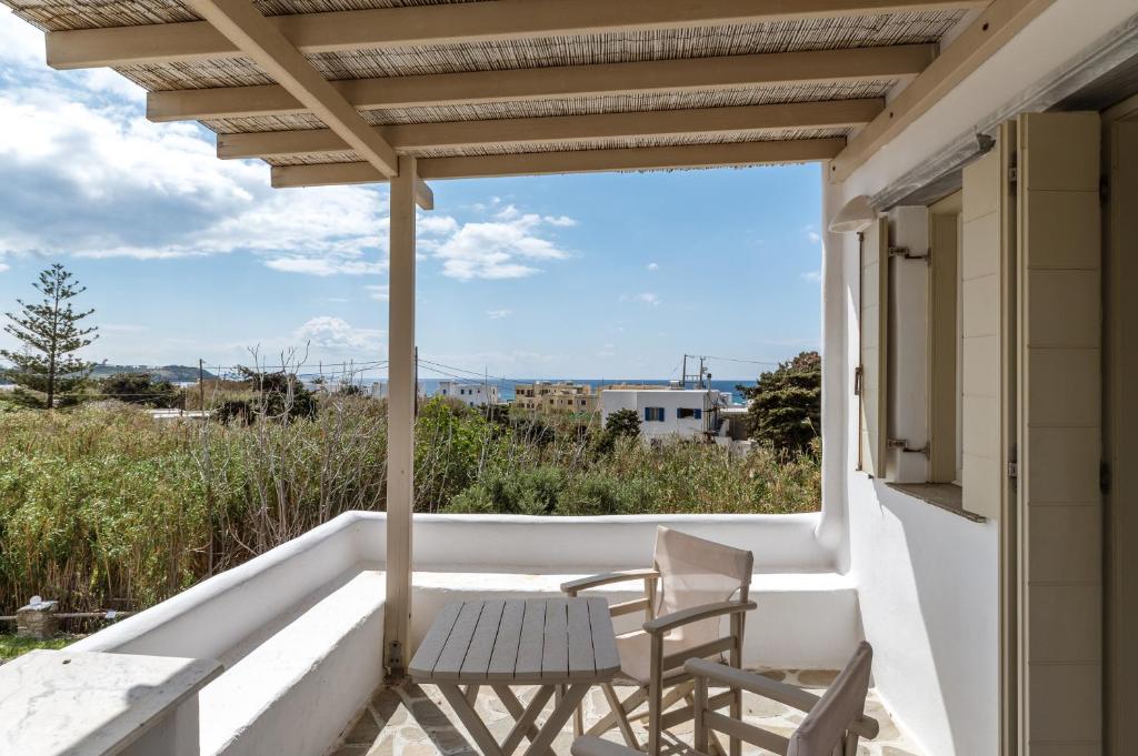 een uitzicht vanaf het balkon van een huis met 2 stoelen bij Ninemia Suites Tinos Superior 201 in Kionia