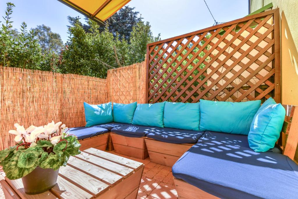a patio with a blue couch and a wooden fence at Casa Minnie in Cavo