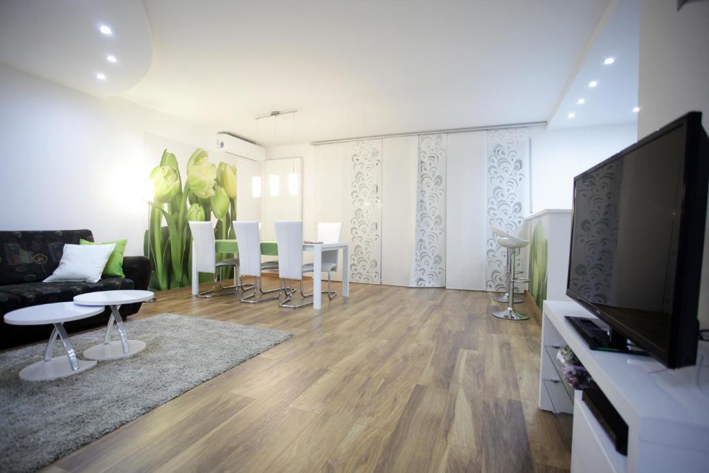 ein Wohnzimmer mit einem Sofa und einem TV in der Unterkunft Bonus Apartments in Zagreb