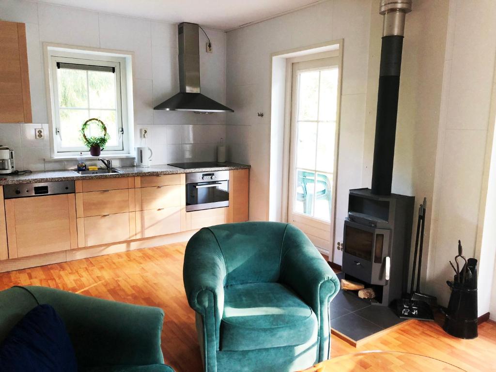 a kitchen with two green chairs and a stove at Eriksmala villa in Eriksmåla