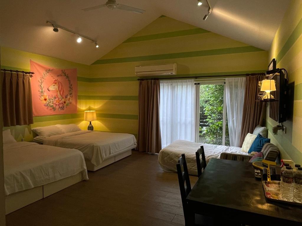a hotel room with two beds and a table and a dining room at Star Wish B&amp;B in Dongshan