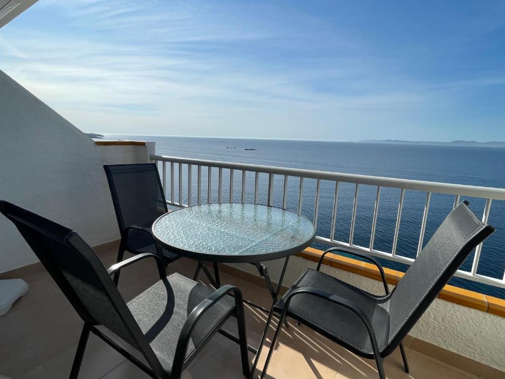 d'un balcon avec une table et des chaises donnant sur l'océan. dans l'établissement Mediterráneo, à Roses